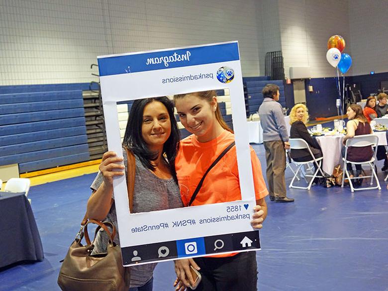 A newly admitted student recreates an Instagram photo by holding up the psnkadmissions instagram frame in front of herself